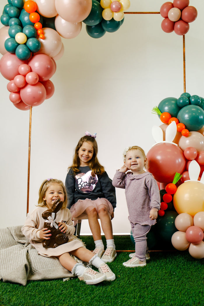 three children in front of balloon display