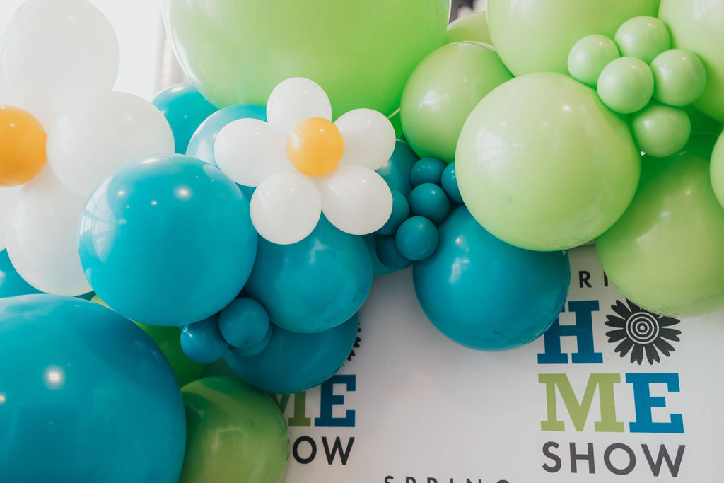 balloon decor with spring daisies on a branded backdrop