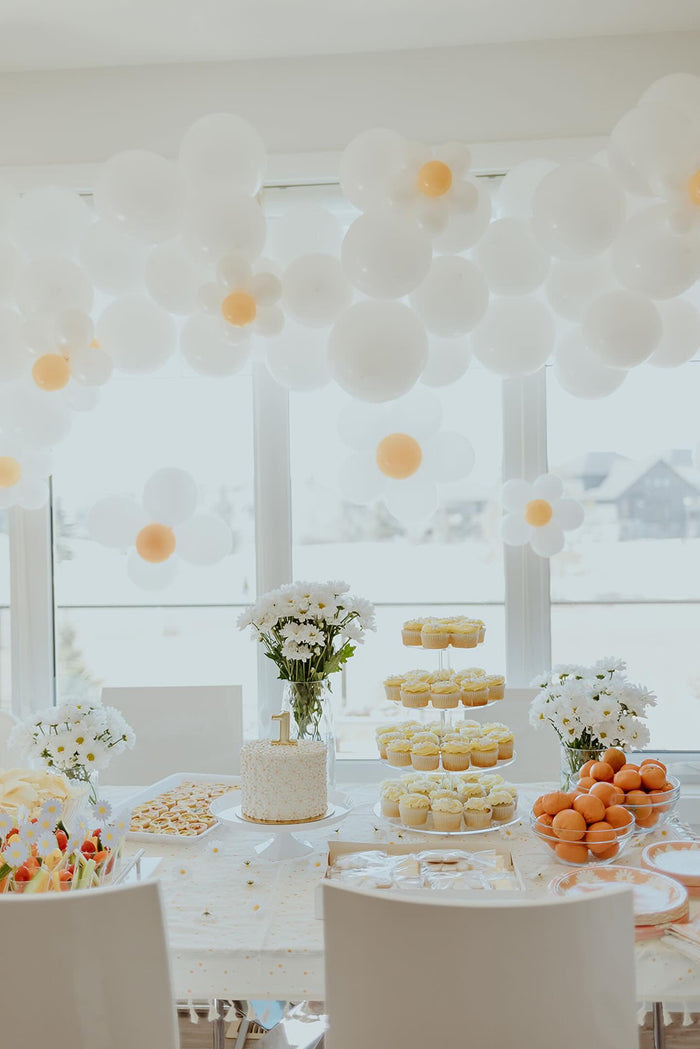 White and yellow balloons create specialty daisy balloon garlands in a bright dining room