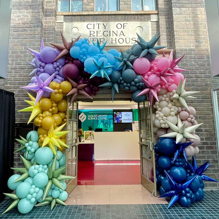 Multicoloured balloon archway with starburst balloon accents