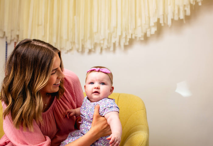 mom looking at baby girl who is looking at camera
